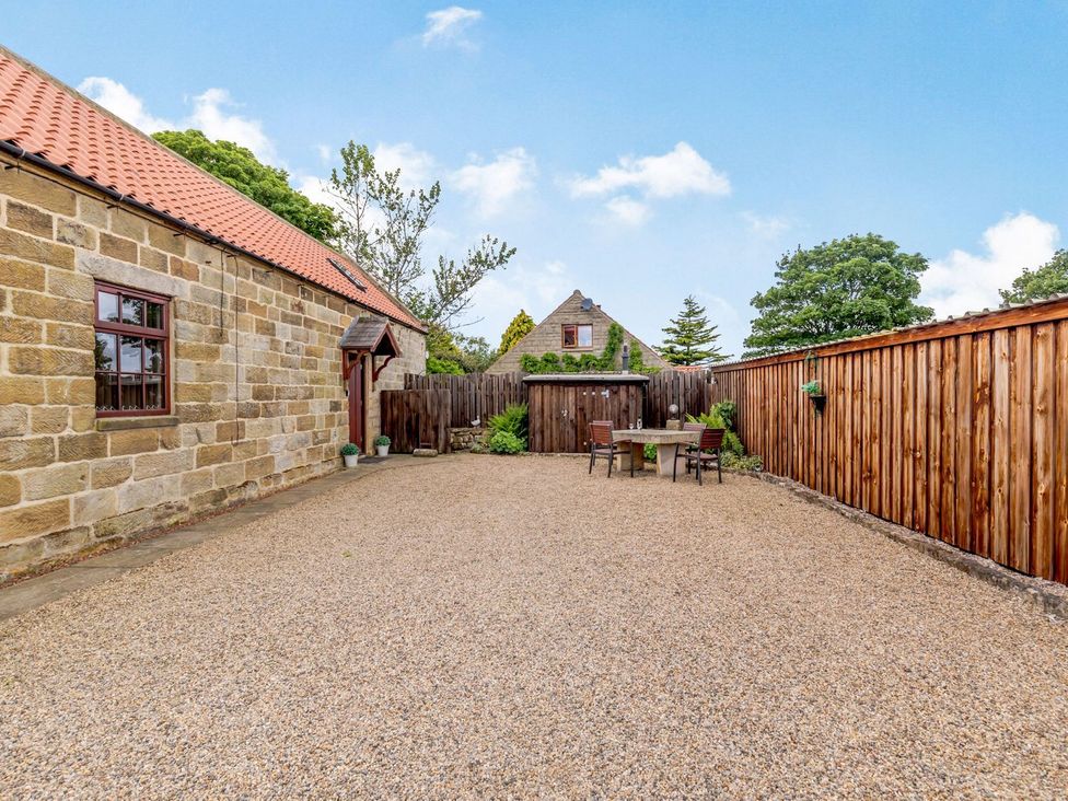An outdoor space with gravel and a table set at Lanes Barn in Whitby