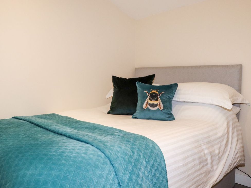 A bed with pillows and a blanket at Lannlyvri Lodge in Lanlivery near Lostwithiel