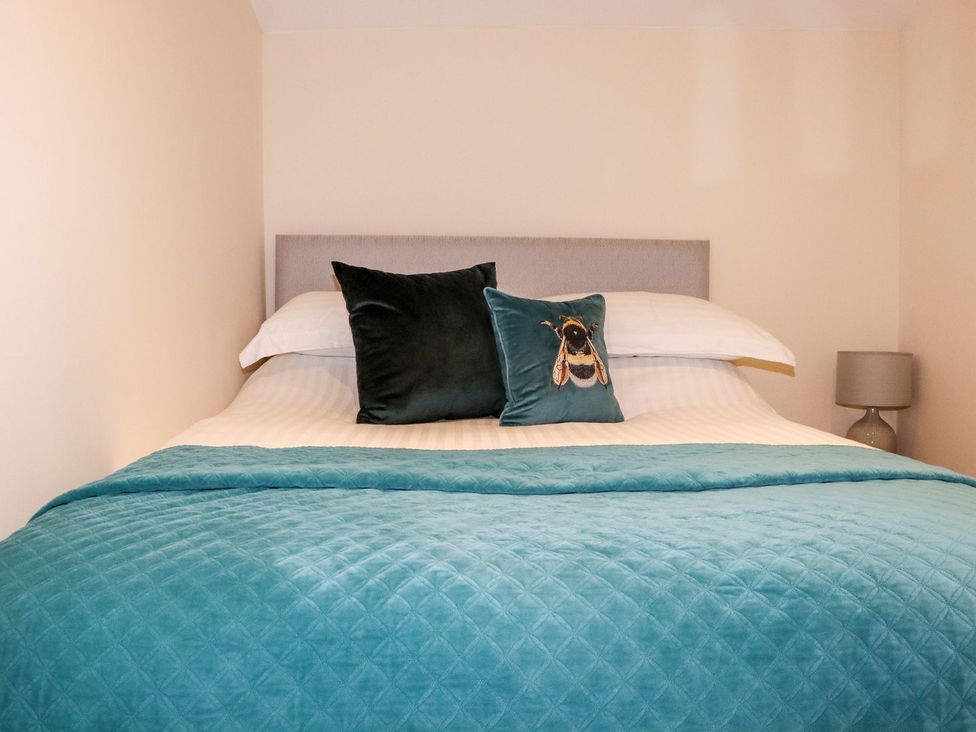 A bedroom with a bed and decorative pillows at Lannlyvri Lodge Lanlivery near Lostwithiel