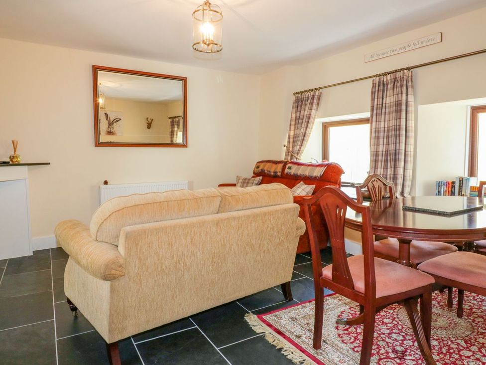 A living room with a sofa and dining table at Camellia Cottage in Bodmin