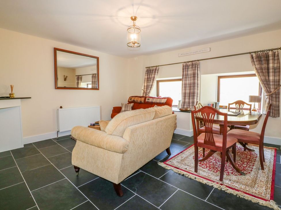 A living room with a sofa and dining table at Camellia Cottage in Bodmin