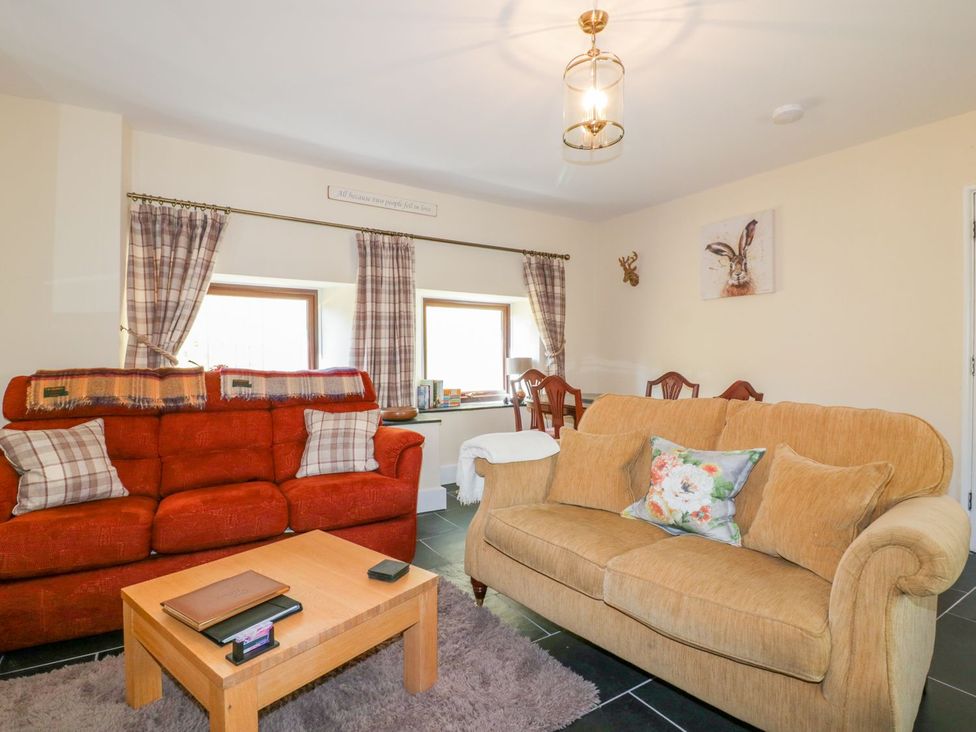 A living room with two sofas and a table at Camellia Cottage in Bodmin