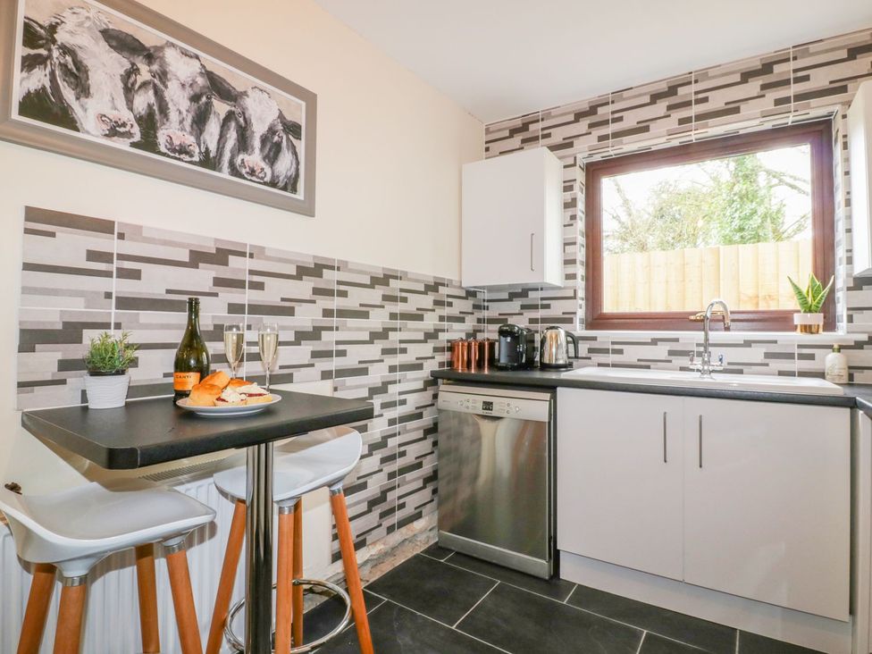 A kitchen with a table and chairs at Camellia Cottage Bodmin