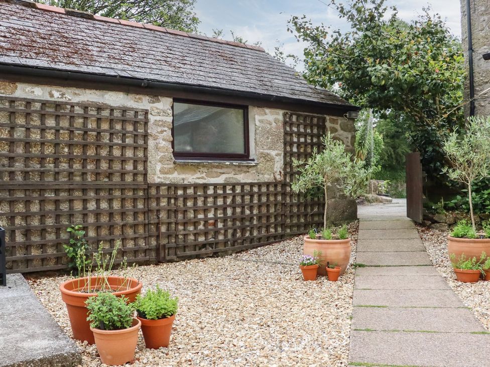 An outdoor area with stone wall and plants at Camellia Cottage in Bodmin