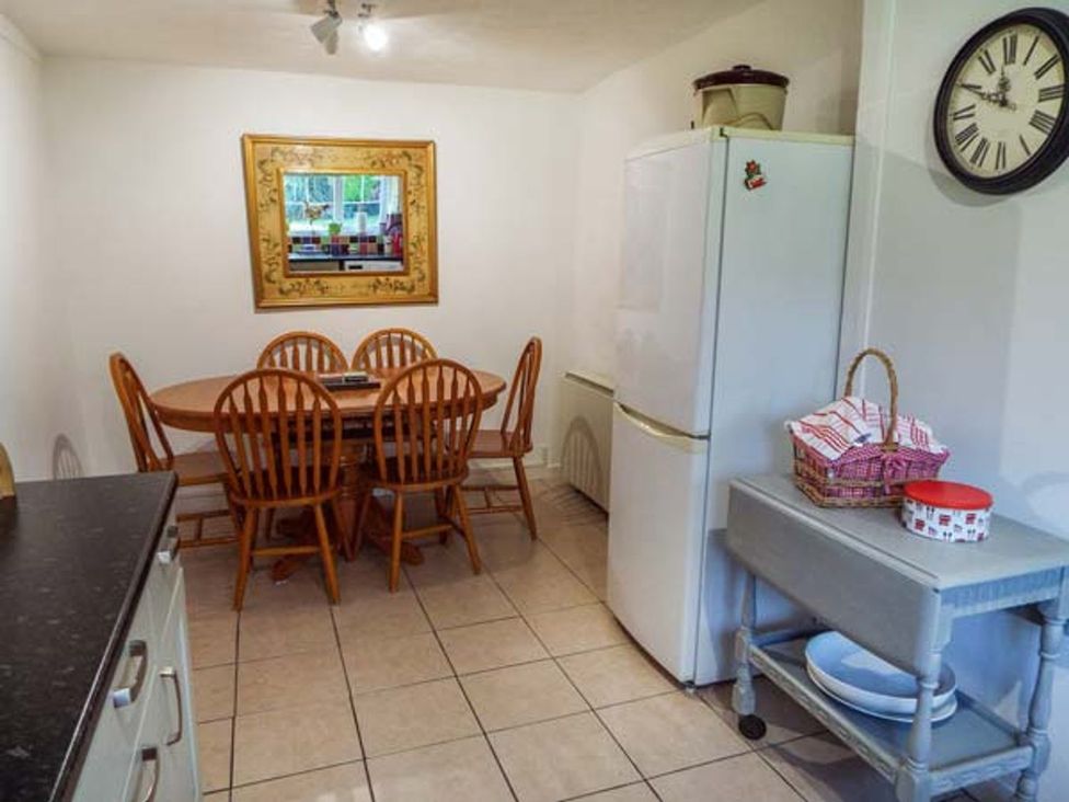 A kitchen with a dining table and chairs at Tyddyn Gyrfa Cottage in Cemaes Bay