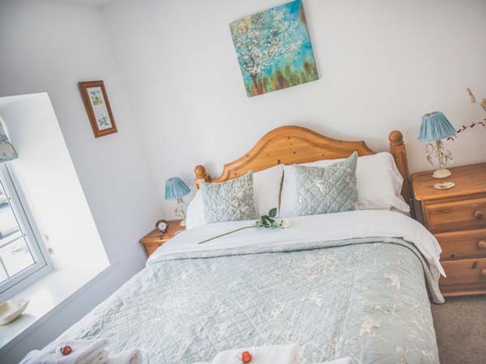 A bedroom with a bed and bedside tables at Tyddyn Gyrfa Cottage in Cemaes Bay