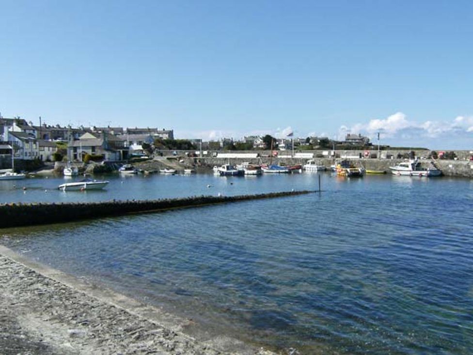 A waterfront view with boats at Tyddyn Gyrfa Cottage in Cemaes Bay