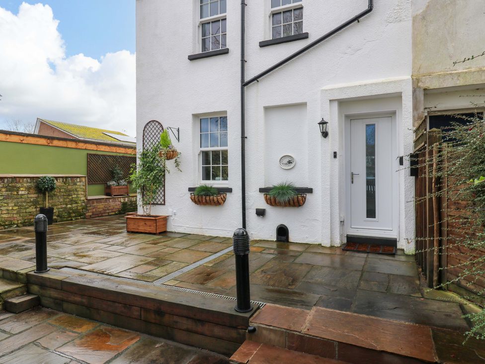 An outdoor area with a door and flower pots at 1A Coastguard Cottages in Rye