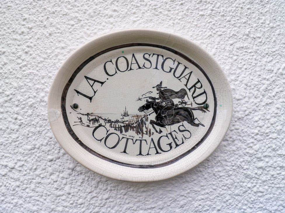 A plaque displaying the name 1A Coastguard Cottages in Rye