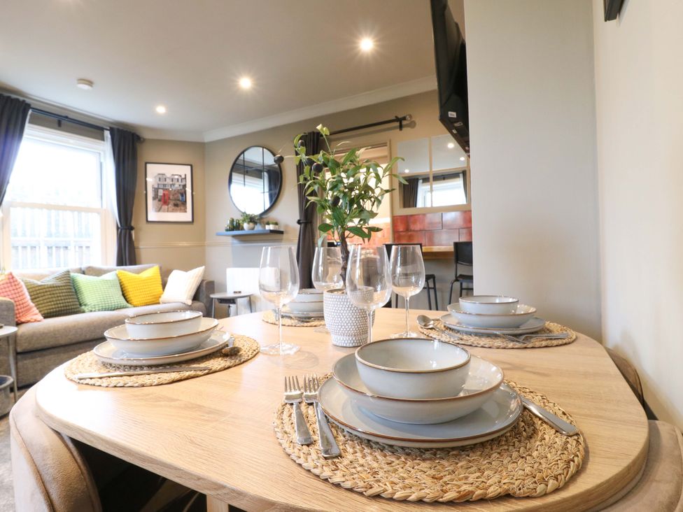 A dining room with a table set for dinner at 1A Coastguard Cottages in Rye
