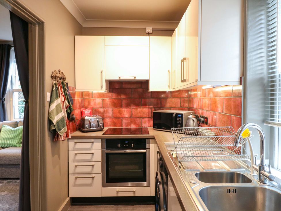 A kitchen with appliances and a sink at 1A Coastguard Cottages in Rye