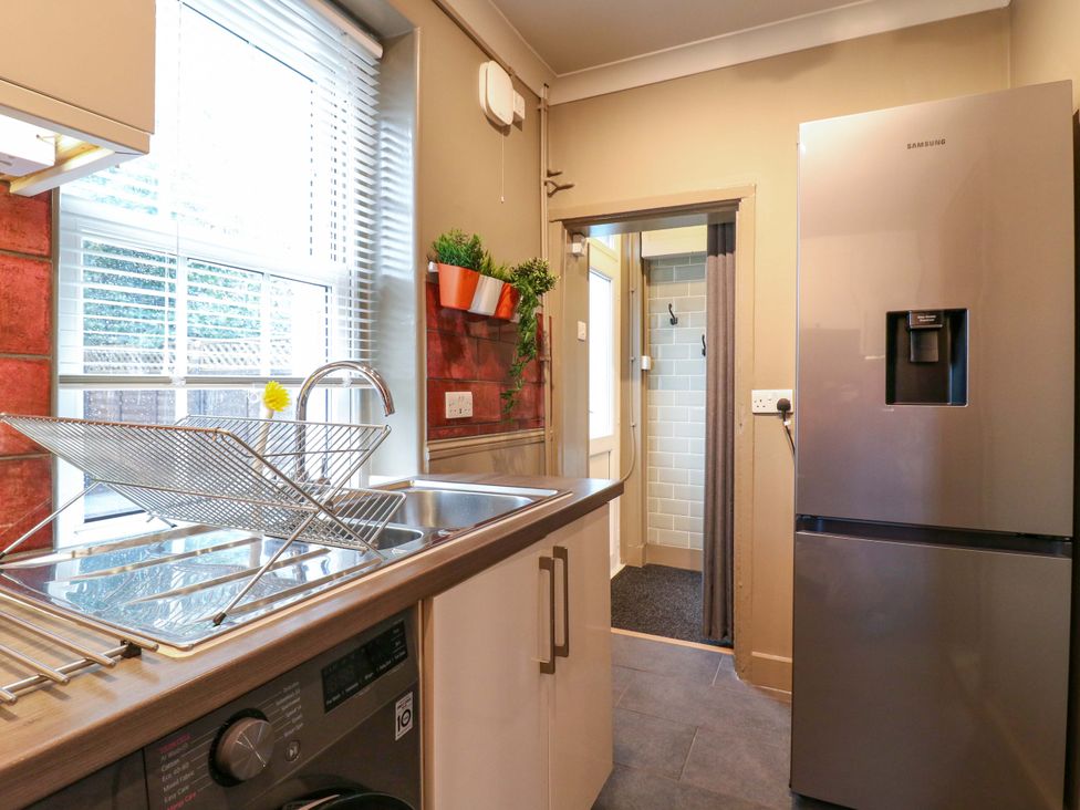 A kitchen with a sink and refrigerator at 1A Coastguard Cottages in Rye