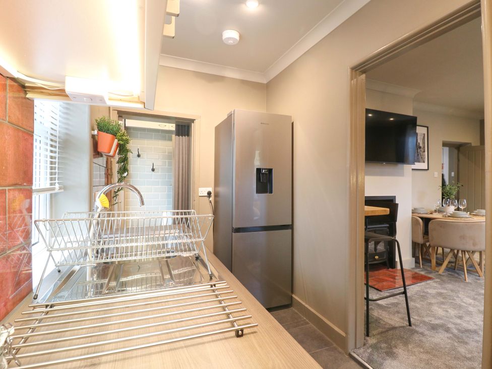A kitchen with a dish rack and refrigerator at 1A Coastguard Cottages in Rye