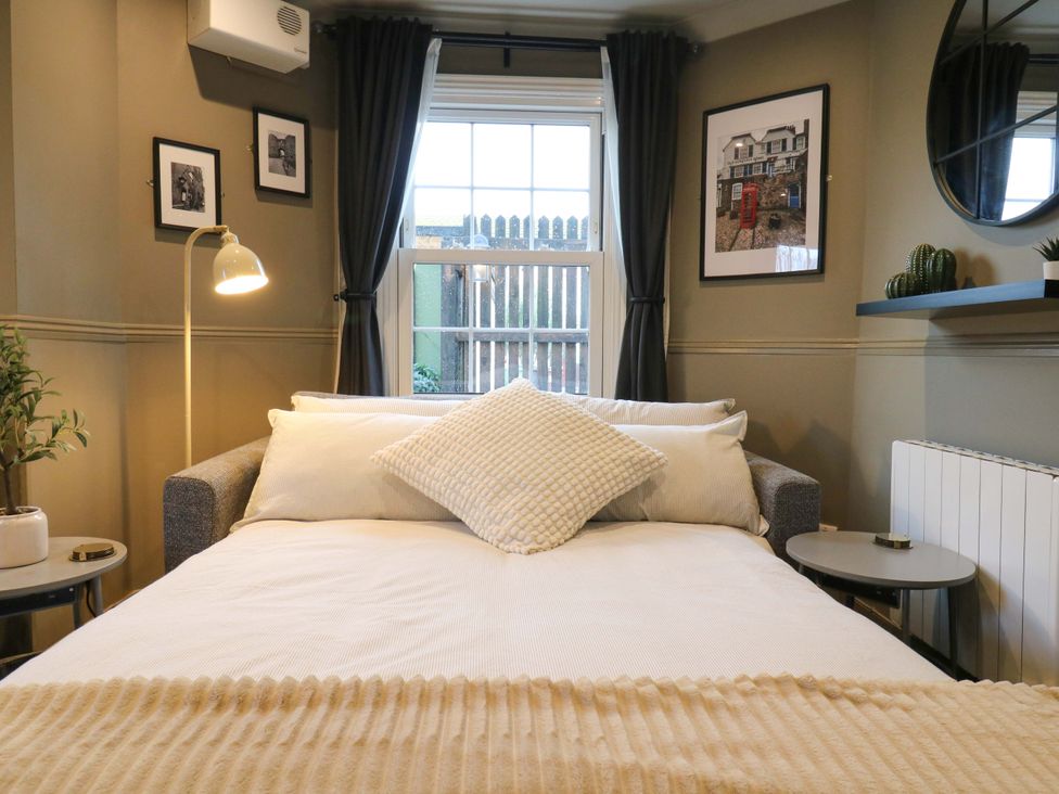 A living room with a sofa and decorative elements at 1A Coastguard Cottages in Rye