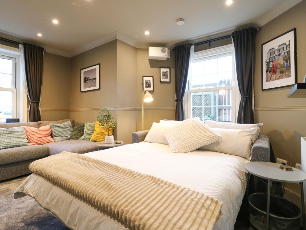 A living room with a bed and sofa at 1A Coastguard Cottages in Rye