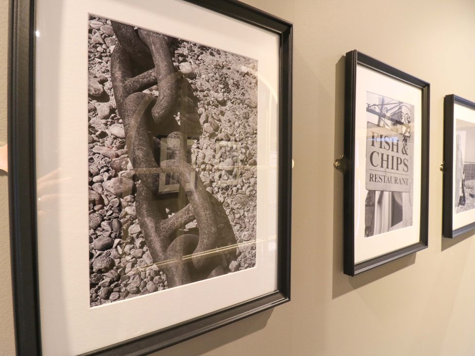 A chain resting on pebbles in a framed picture at 1A Coastguard Cottages, Rye