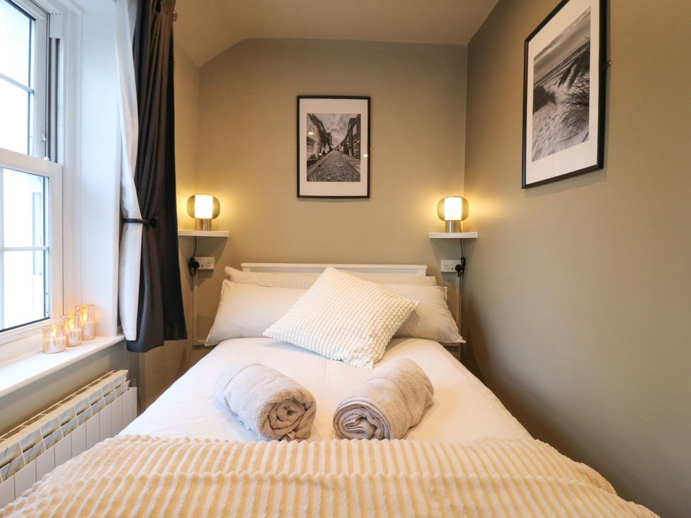 A bedroom with a bed and decorative items at 1A Coastguard Cottages Rye