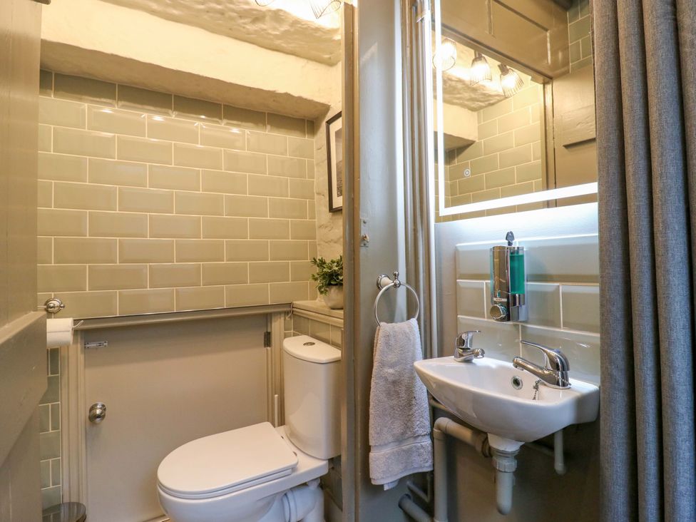 A bathroom with a toilet and hand basin at 1A Coastguard Cottages in Rye
