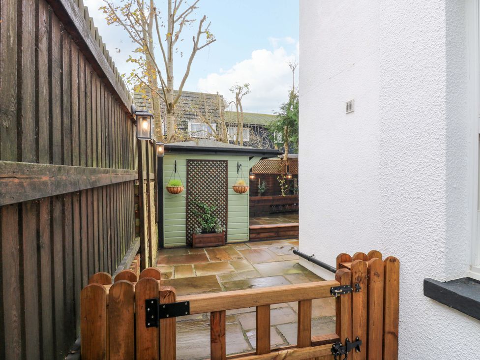 A garden with a gate and a shed at 1A Coastguard Cottages in Rye