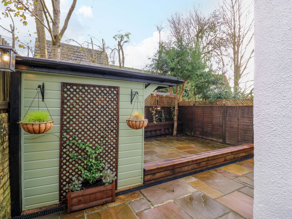 A garden with a shed and paved area at 1A Coastguard Cottages in Rye