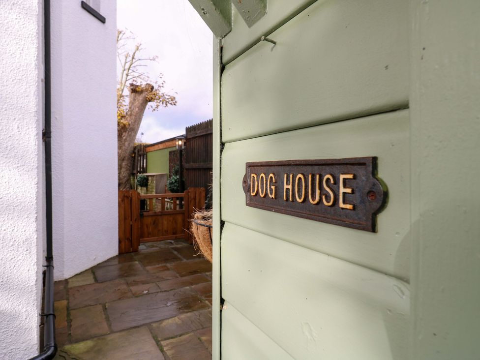 A dog house sign next to a patio at 1A Coastguard Cottages in Rye