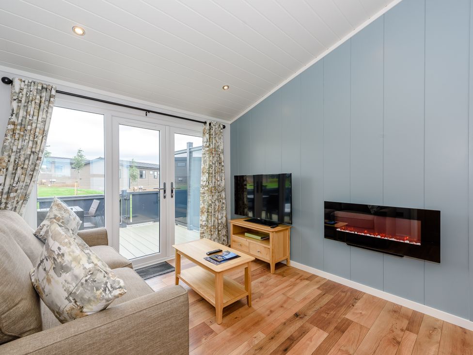 A living room with a sofa and television at Coniston (Pet) Penrith