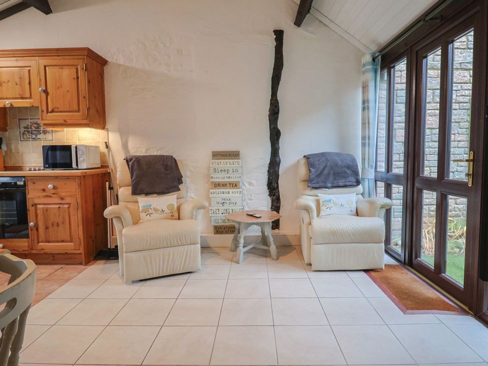 A snug with kitchen features and seating at Apple Cottage in Whitchurch Canonicorum