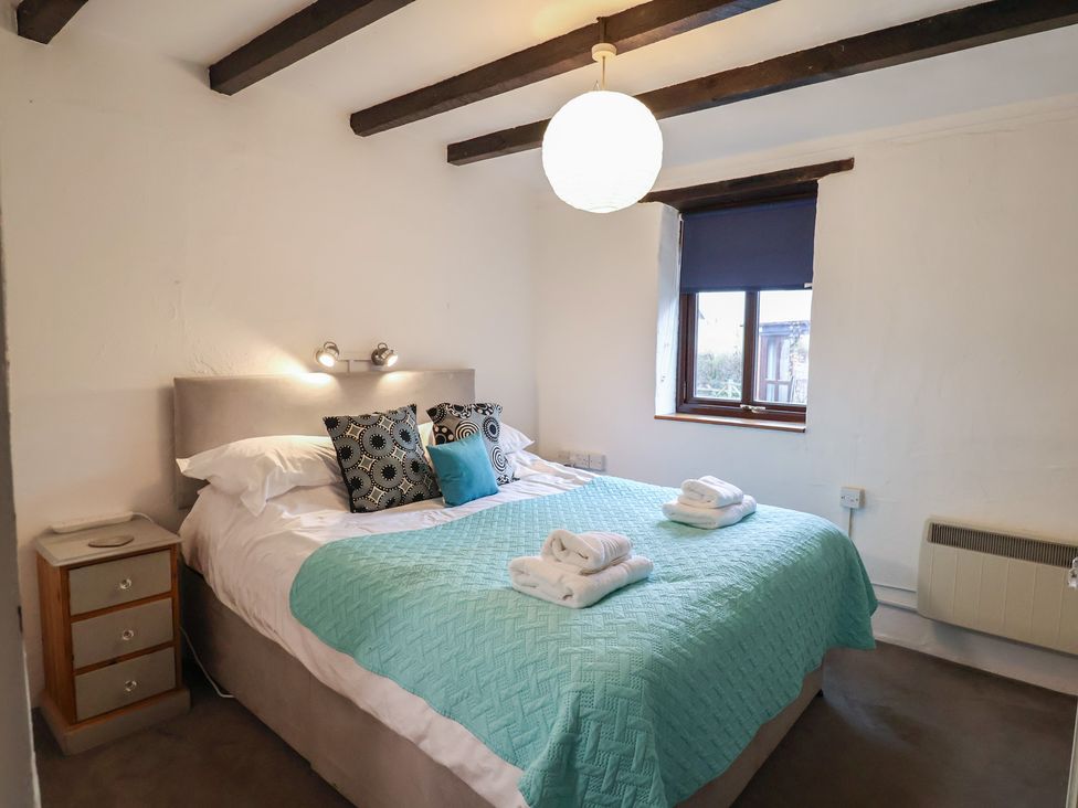 A bedroom with a bed and bedside table at Apple Cottage in Whitchurch Canonicorum