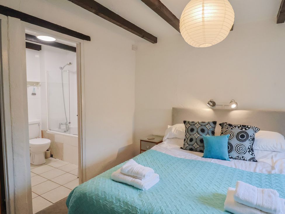 A bedroom with a bed and adjoining bathroom at Apple Cottage Whitchurch Canonicorum