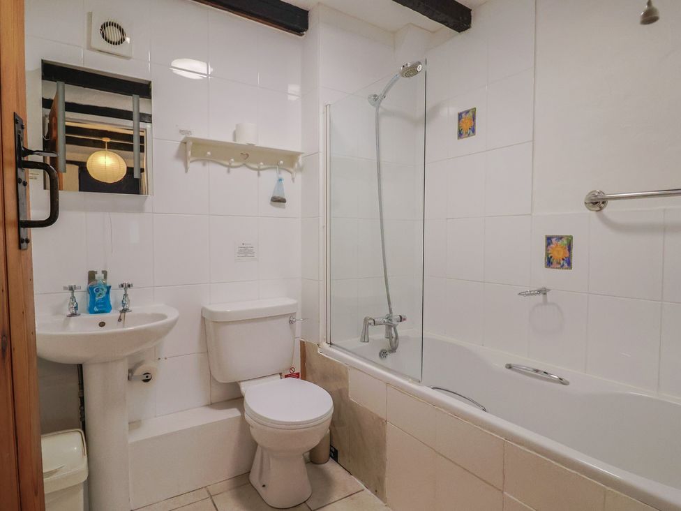 A bathroom with a sink, toilet, and bathtub at Apple Cottage in Whitchurch Canonicorum