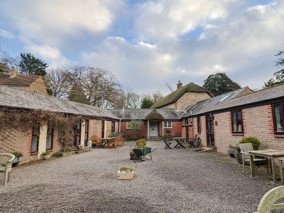 An outdoor area with buildings and seating at Apple Cottage in Whitchurch Canonicorum
