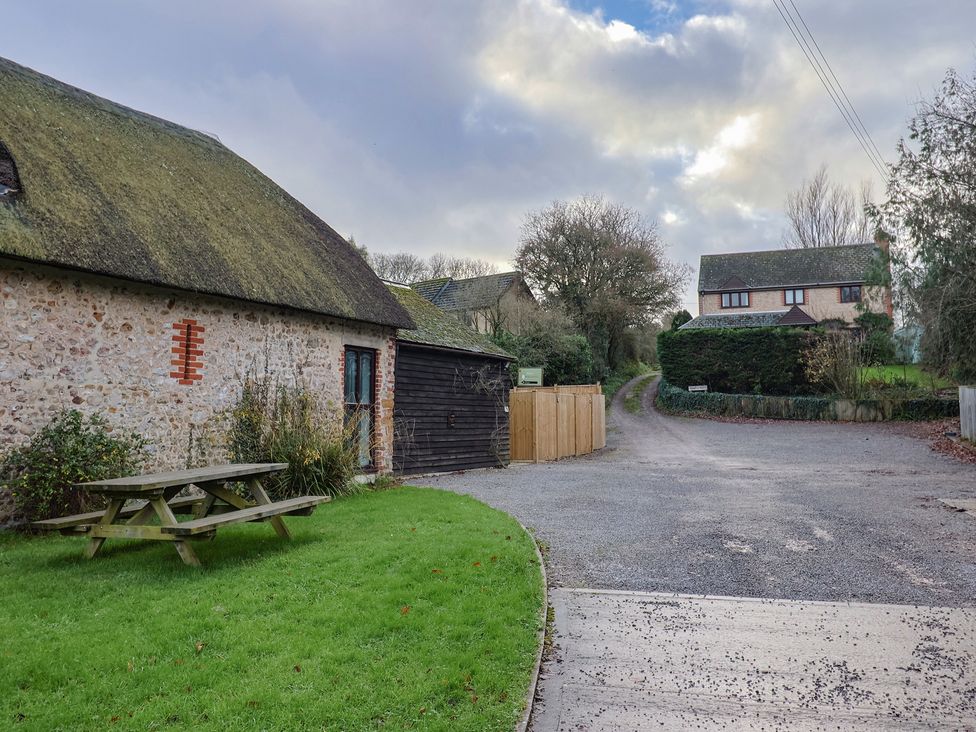 An outdoor view with a gravel road and buildings at Apple Cottage Whitchurch Canonicorum