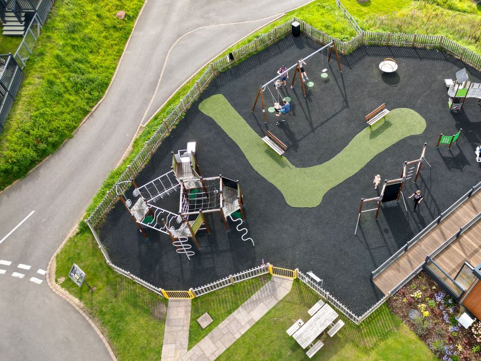 An outdoor playground with swings and climbing equipment at Blencathra Family in Penrith