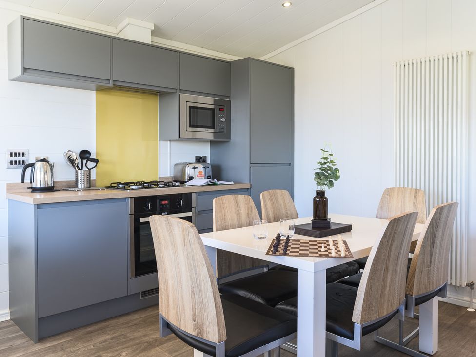 A kitchen with a dining table and chairs at Blencathra Family (Pet) in Penrith