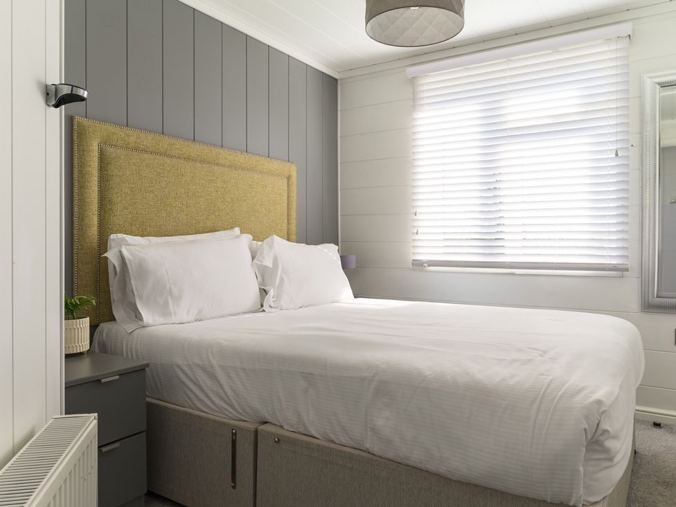 A bedroom with a bed and nightstand at Blencathra Family (Pet) in Penrith