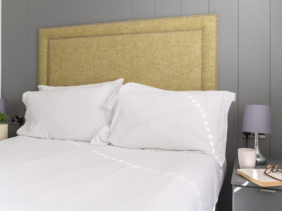 A bedroom with a bed and lamps at Blencathra Family (Pet) in Penrith