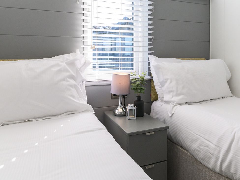 A bedroom with two beds and a nightstand at Blencathra Family (Pet) Penrith