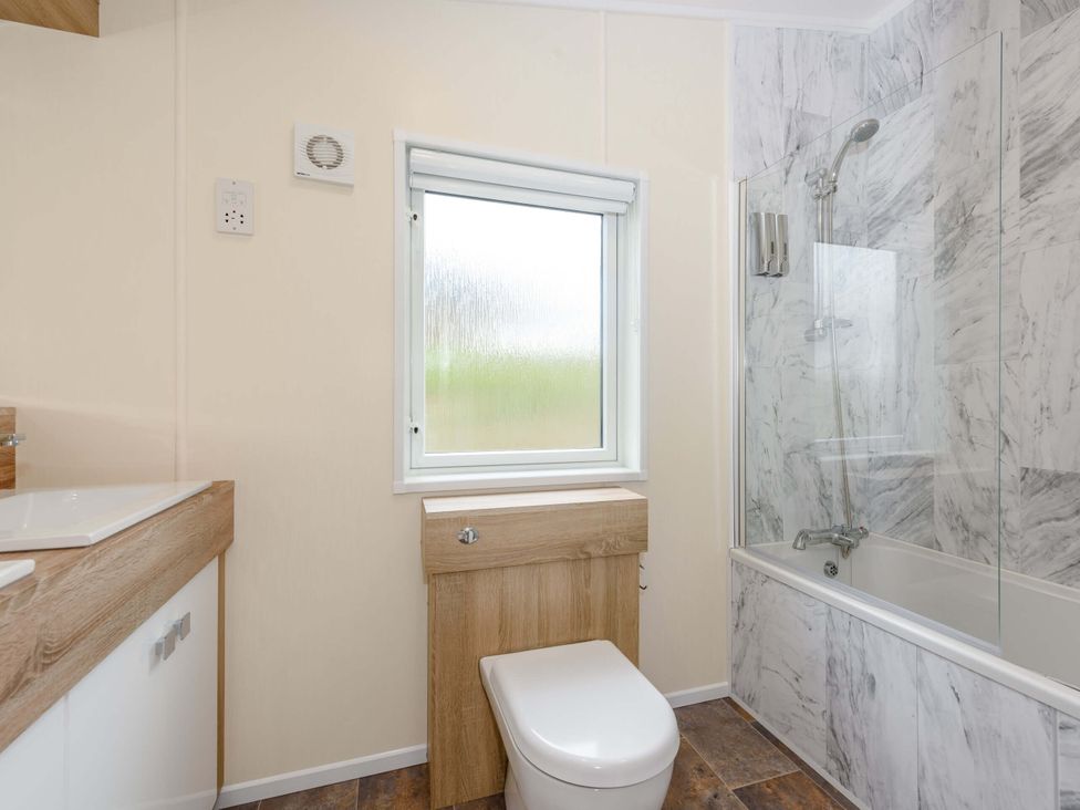 A bathroom with a bathtub and toilet at Keswick in Penrith