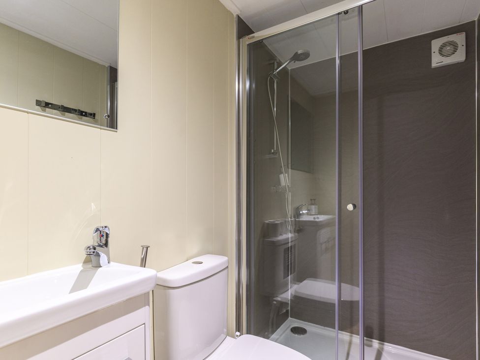 A bathroom with a shower, sink, and toilet at Pods by the Lake Penrith