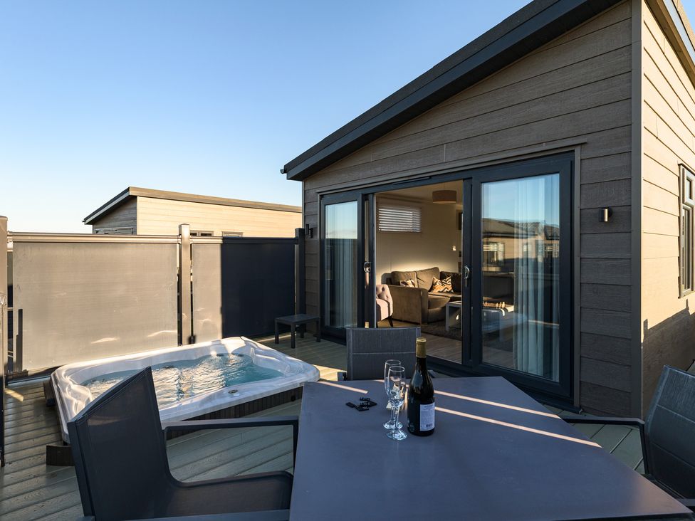 An outdoor area with a hot tub and seating at Grasmere (Pet) Penrith