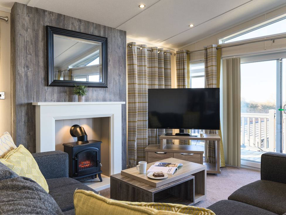 A living room with a television and fireplace at Keswick (Pet) Penrith