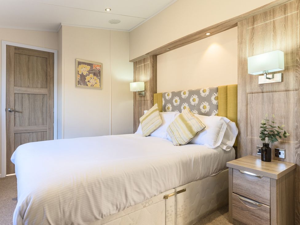 A bedroom with a double bed and bedside table at Keswick (Pet) in Penrith