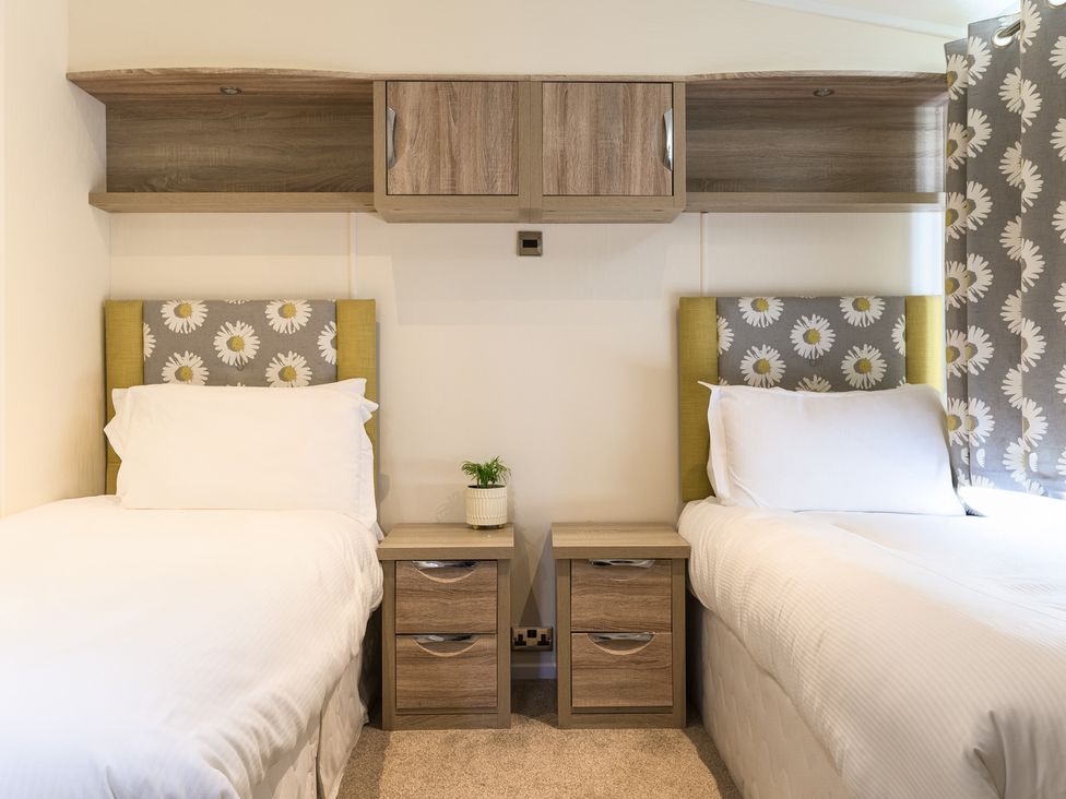 A bedroom with twin beds and bedside tables at Keswick (Pet), Penrith