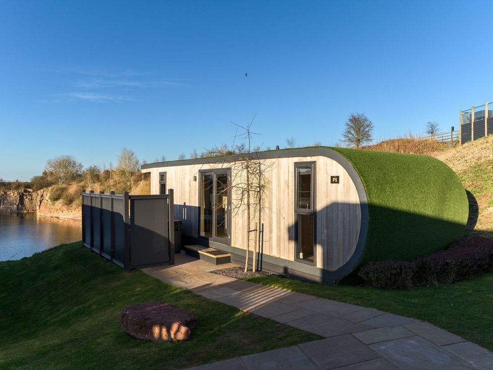 A cabin by the lake with a path at Pods by the Lake (Pet) Penrith