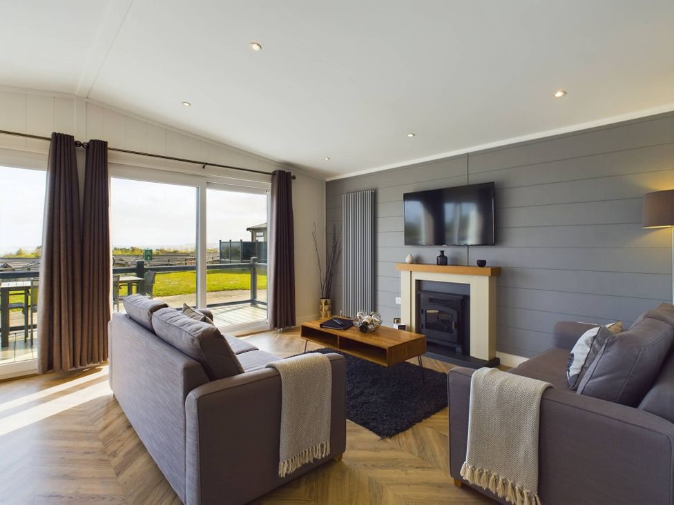 A living room with a sofa and coffee table at Spa Sauna Lodge in Penrith