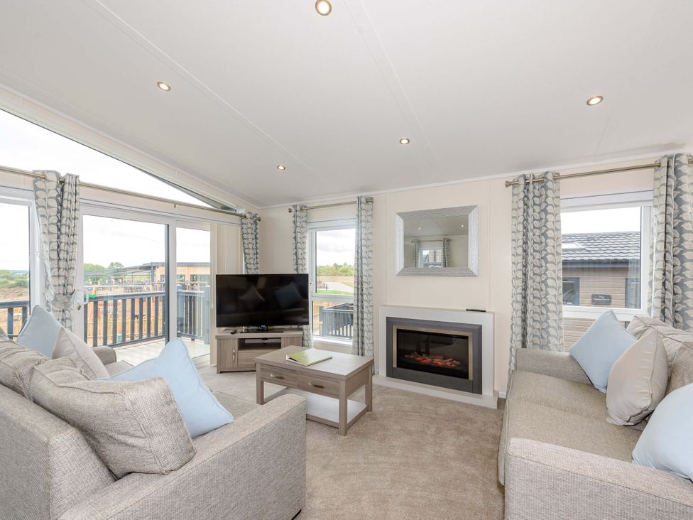 A living room with a television and fireplace at Helvellyn in Penrith