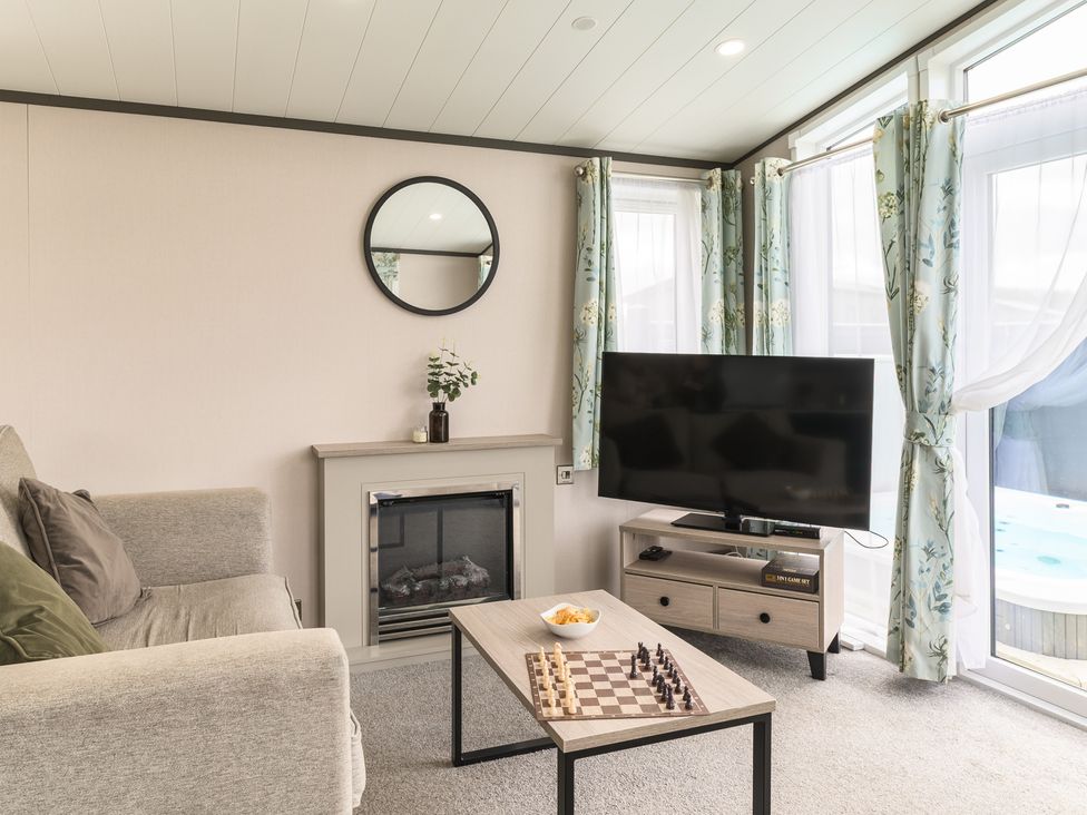 A living room with a television and coffee table at Blencathra Spa (Pet) in Penrith
