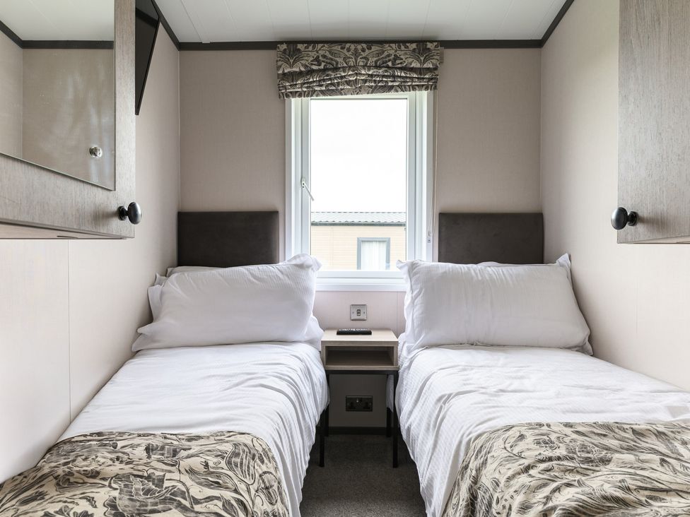 A bedroom with two single beds and a window at Blencathra Spa (Pet) in Penrith