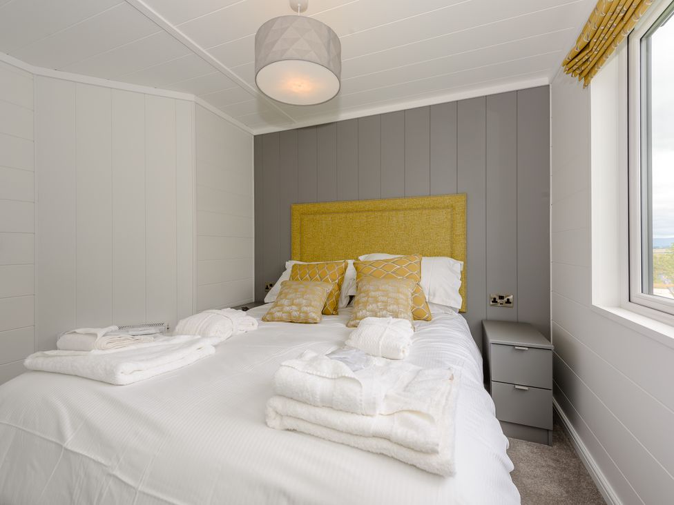 A bedroom with a bed and nightstand at Blencathra Spa (Pet) Penrith