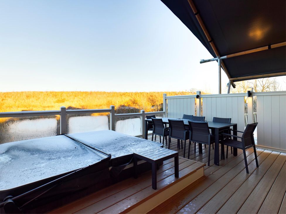 An outdoor area with a hot tub and dining set at Kruger in Penrith